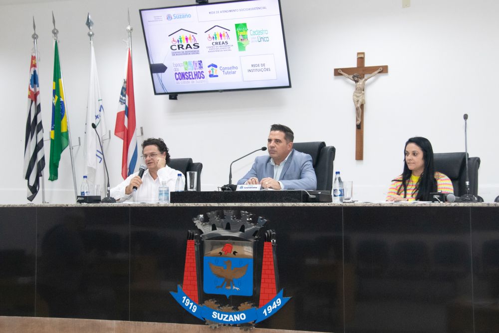 Descrição da imagem #PraCegoVer: em audiência realizada no ano passado, estão sentados na Mesa Diretiva da Câmara, da esquerda para a direita, Geraldo Garippo (com microfone na mão), vereador Leandrinho e Regiane Borges, diretora da Secretaria de Assistência e Desenvolvimento Social.